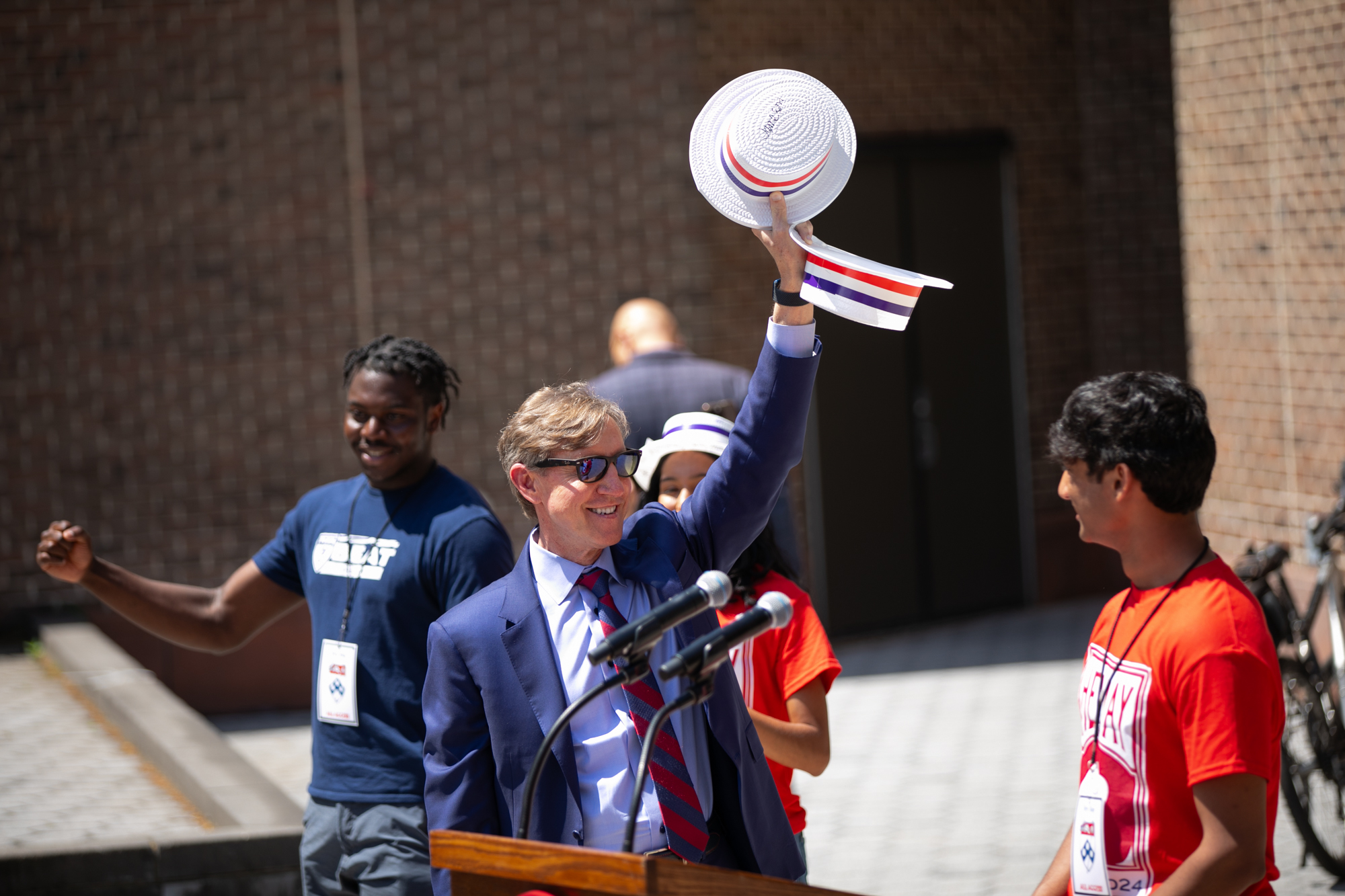 interim president jameson holds up the hey day hat