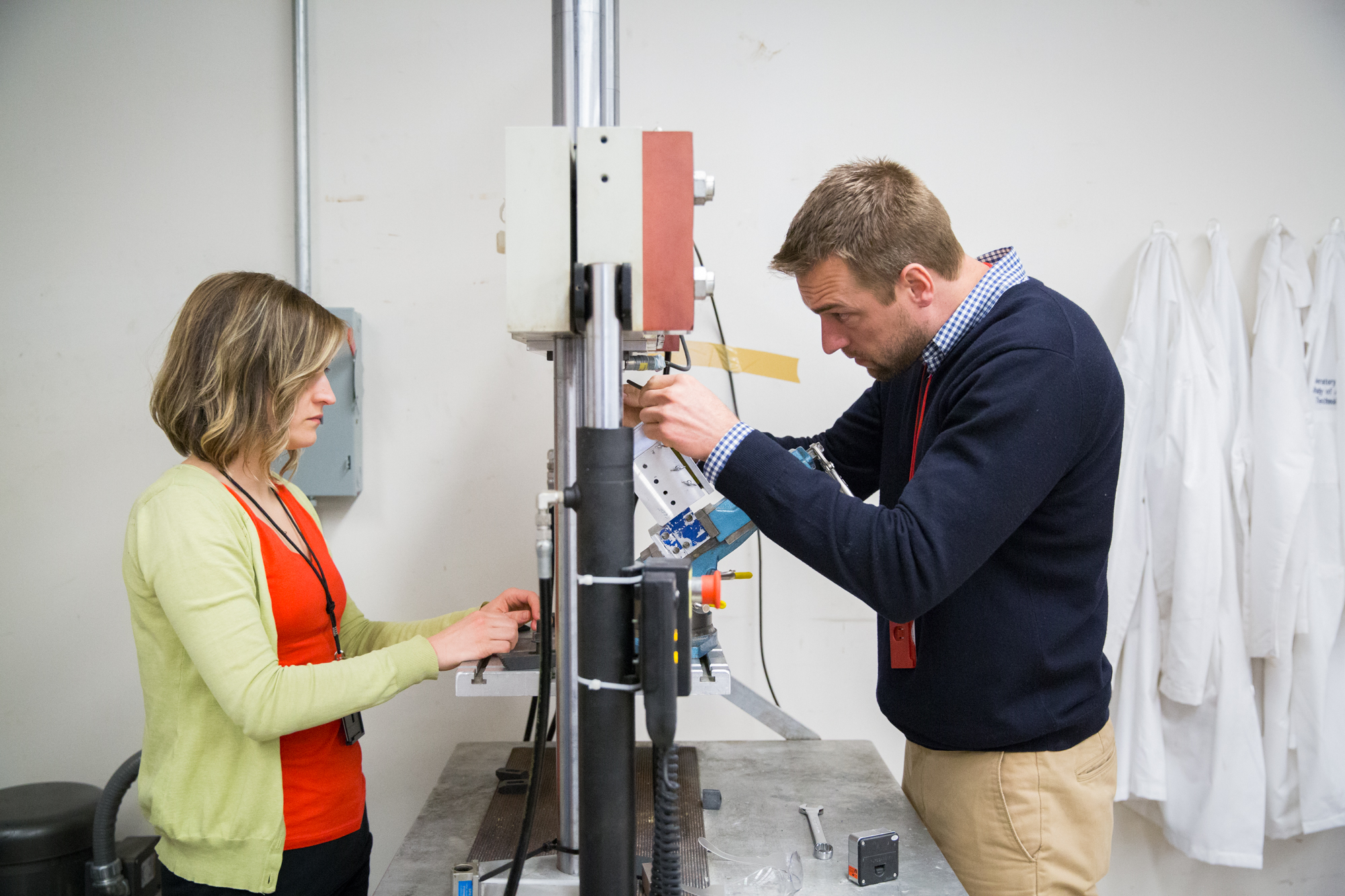 2 researchers using a hydraulic-powered machine