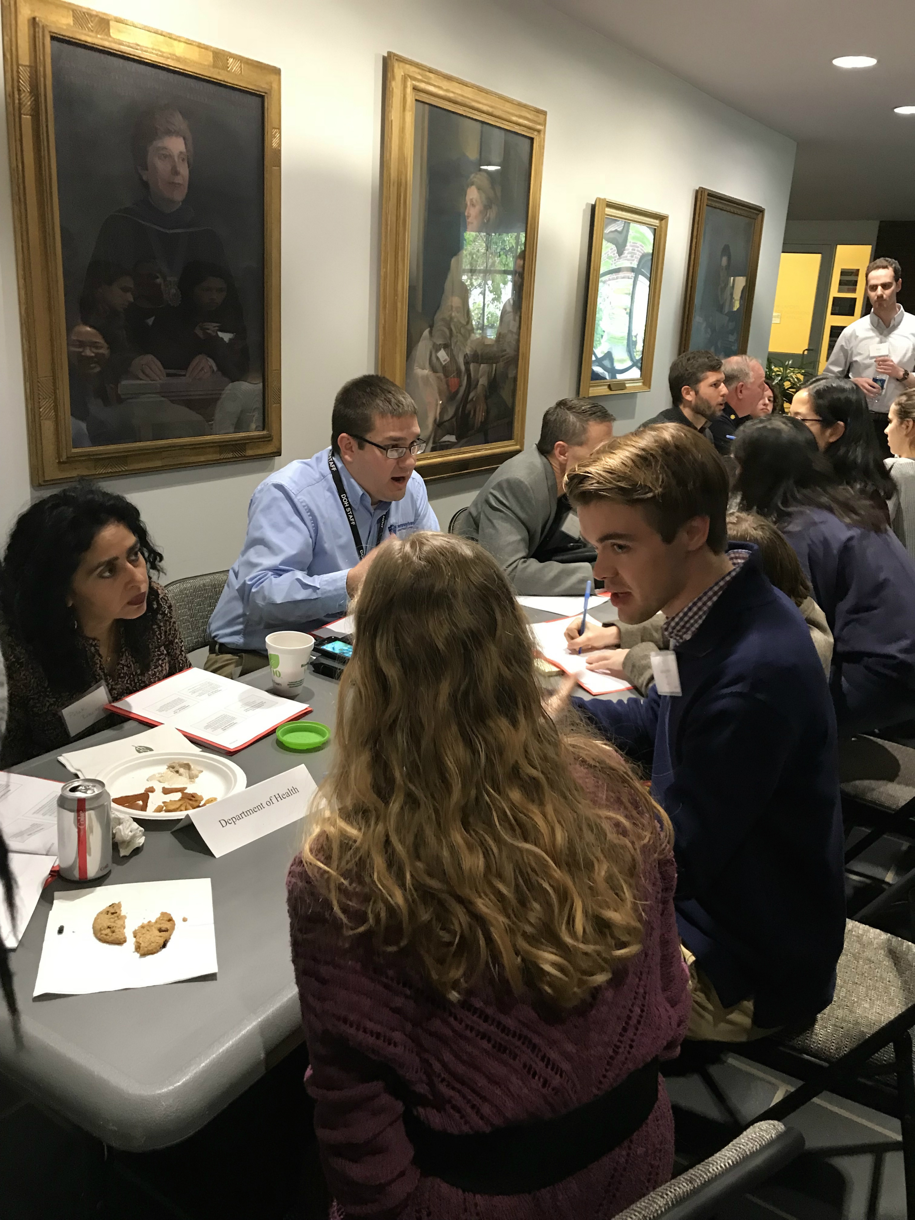 Students talk with experts in public health at tables