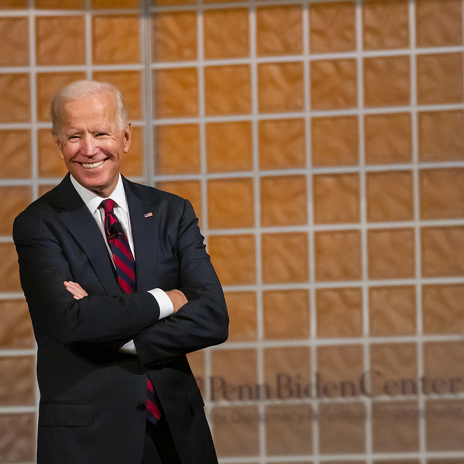 joe biden on stage with arms crossed