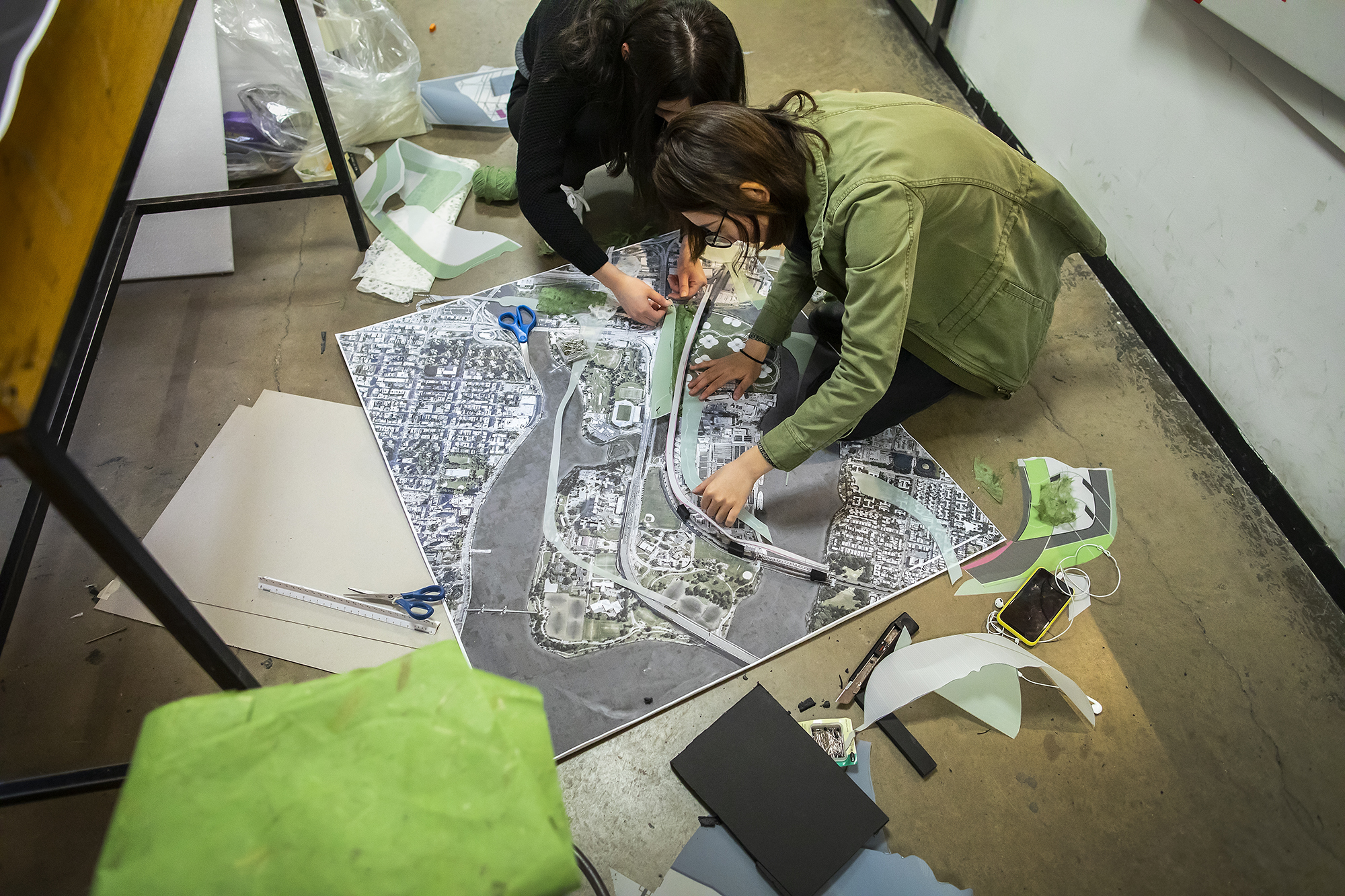 student on the floor working on landscape architecture maps