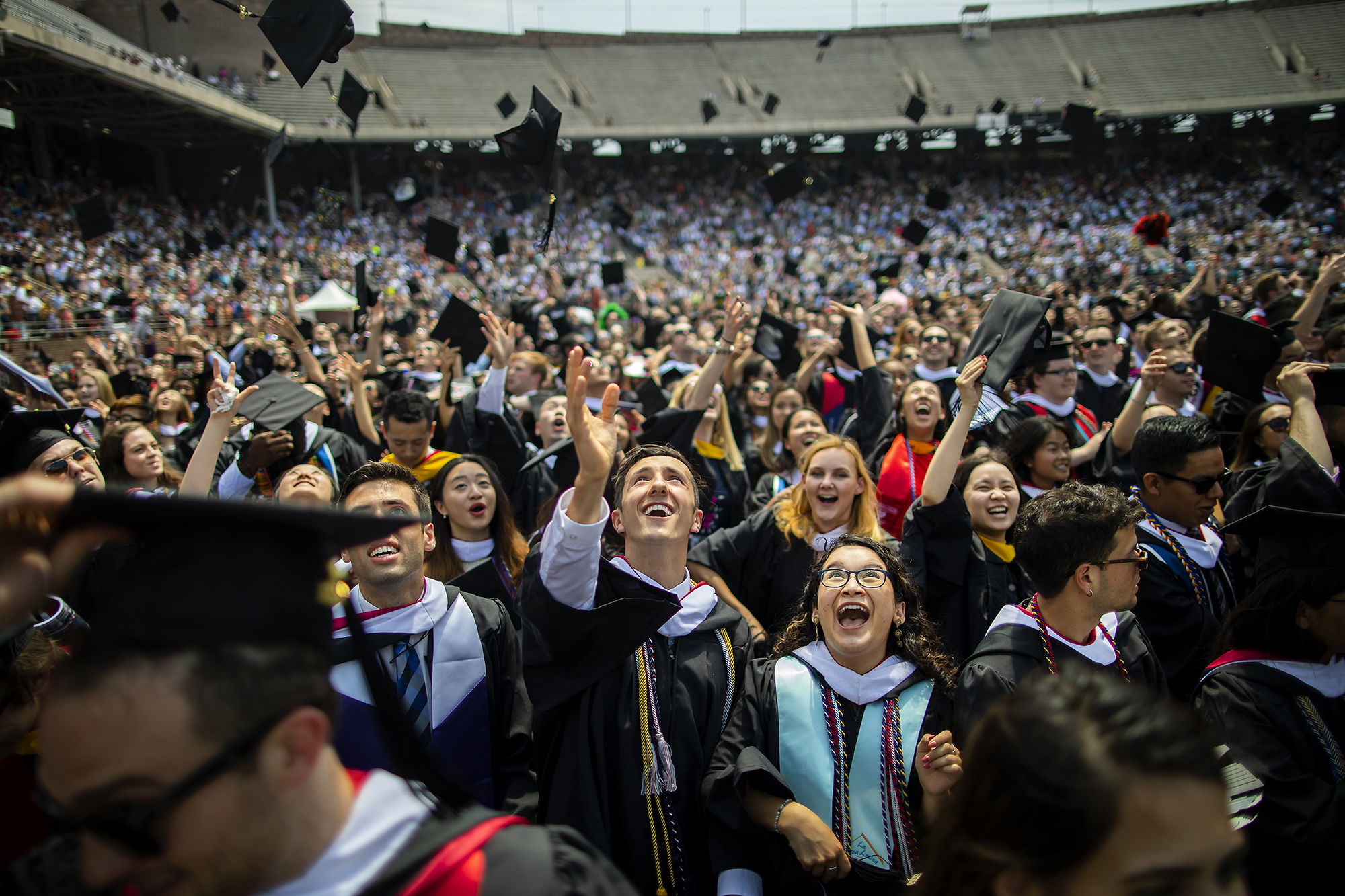 Graduating students toss their caps in the air.