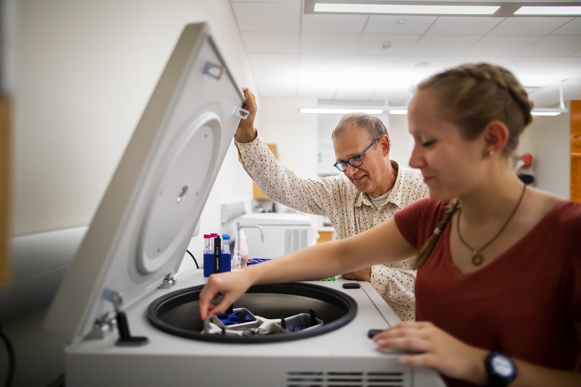 john wagner helping student with a centrifuge