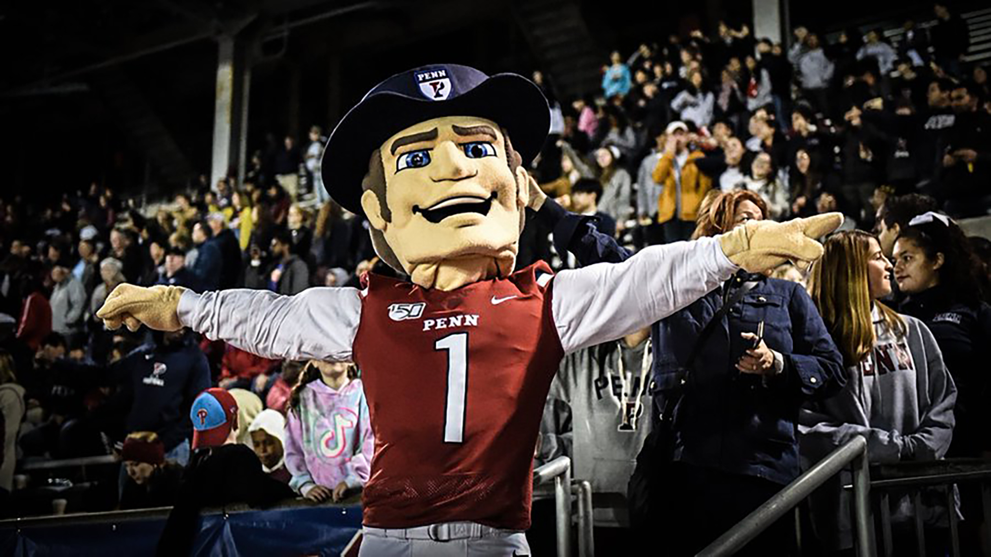 The new Quaker mascot poses with his arms outstretched in the stands at Franklin Field.