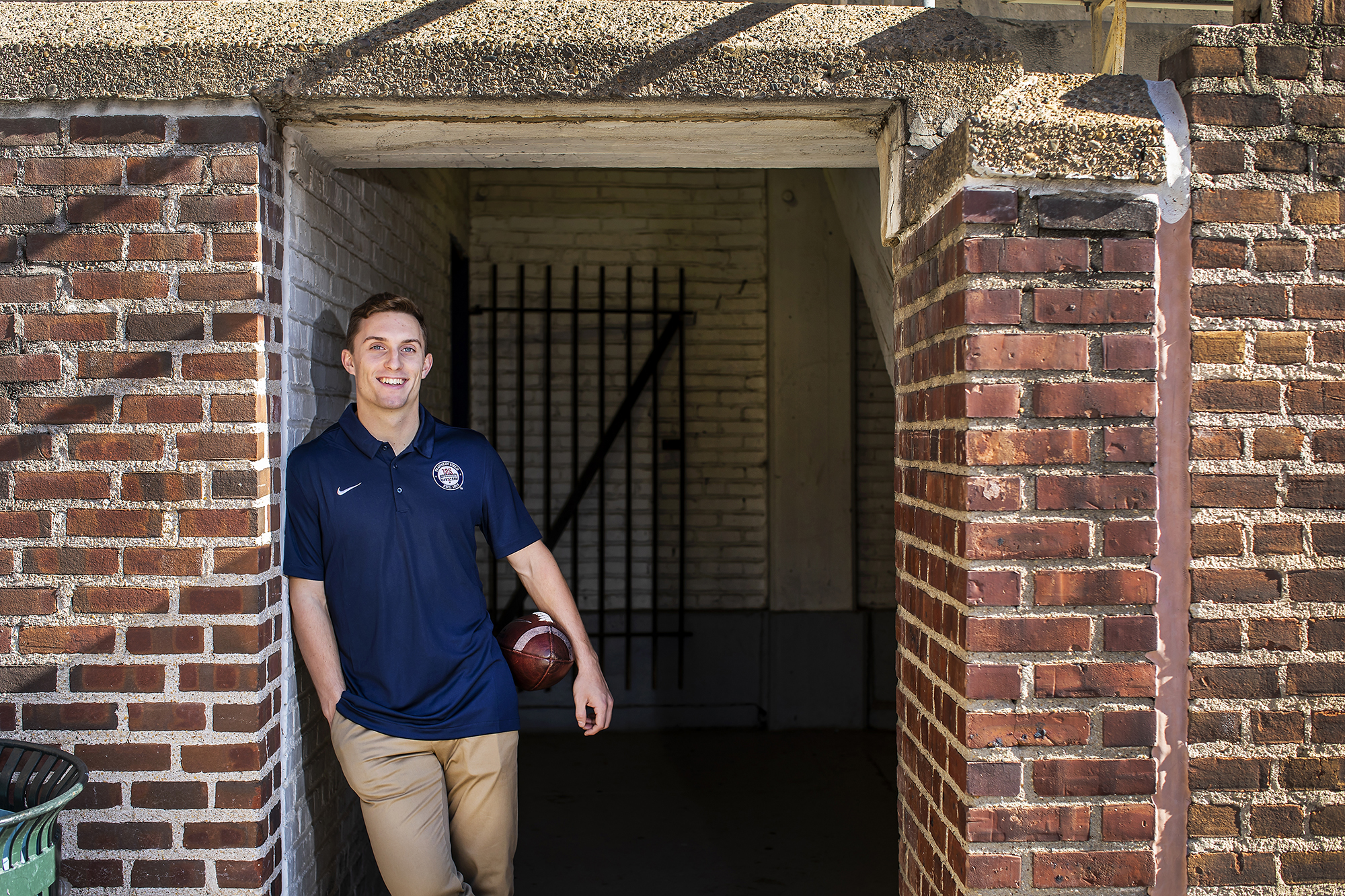 Eddie Jenkins holds a football under his arm while posing in a tunnel at Franklin Field.