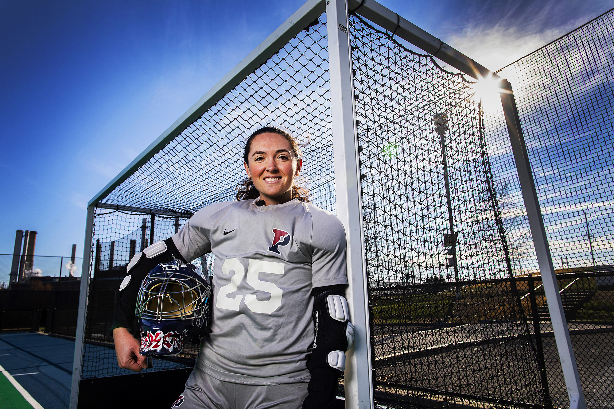 Ava Rosati of the field hockey team poses in her goalie pads in a goal at Vagelos Field.