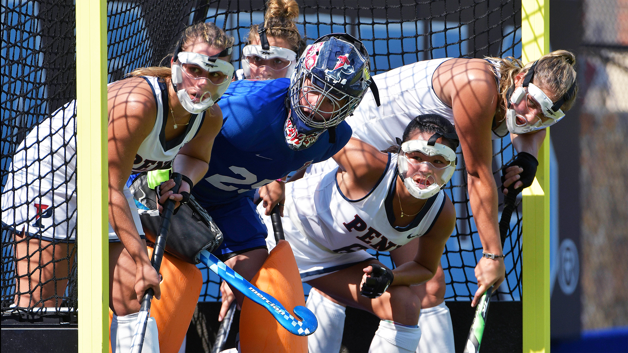 Ava Rosati stands inside the goal with her teammates during a corner during a field hockey game.