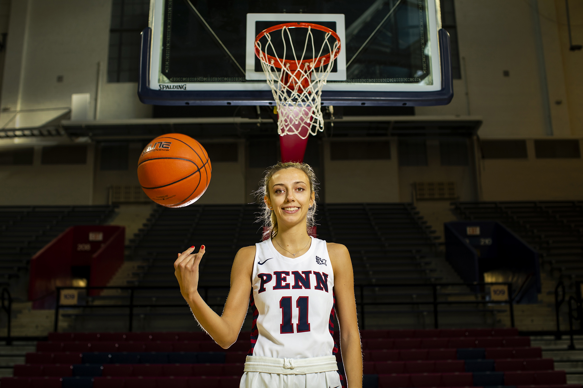 In front of the basket at the Palestra, Kendall Grasela tosses a ball in the air.