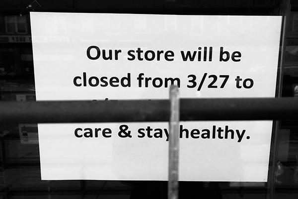 Posted sign partially obscured by window bars that reads: Our store will be closed from 3/27 to…care and stay healthy.