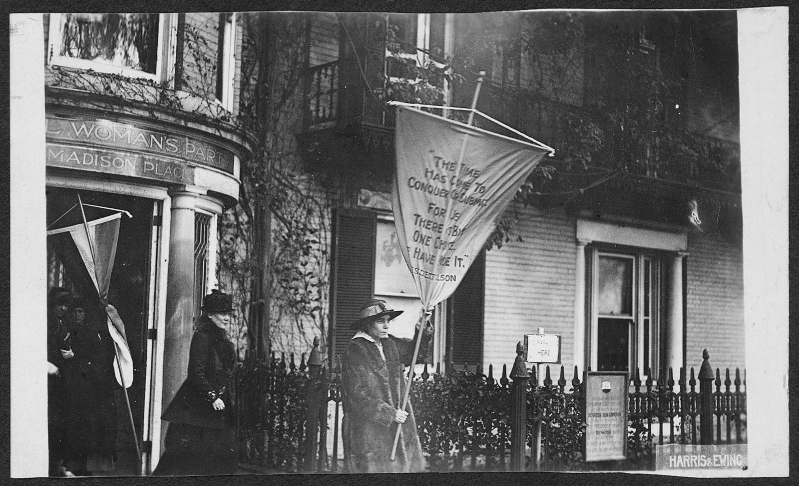 Alice Paul standing with a large banner on a picket line in 1917.