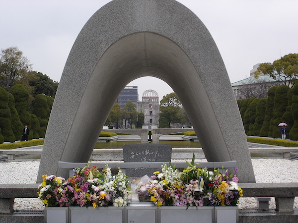 Arch at Hiroshima Peace Memorial with flowers in front of it.