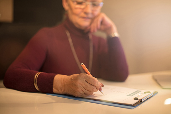 Person sitting at desk filling out paperwork