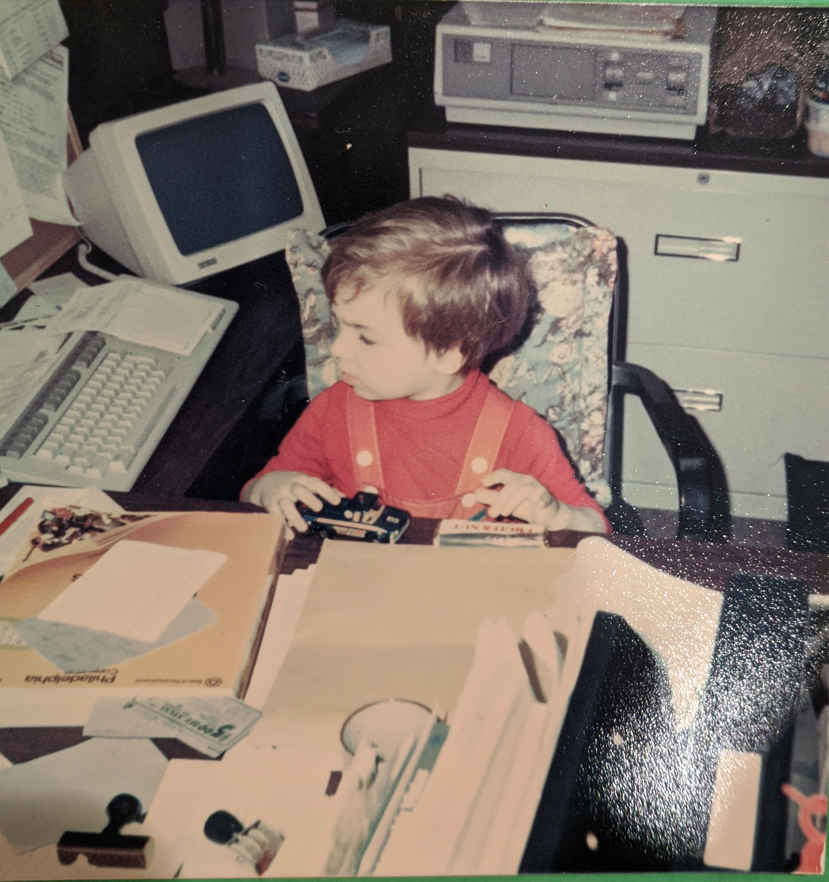 Miller's son Andrew sits at desk with toy car at Almanac office