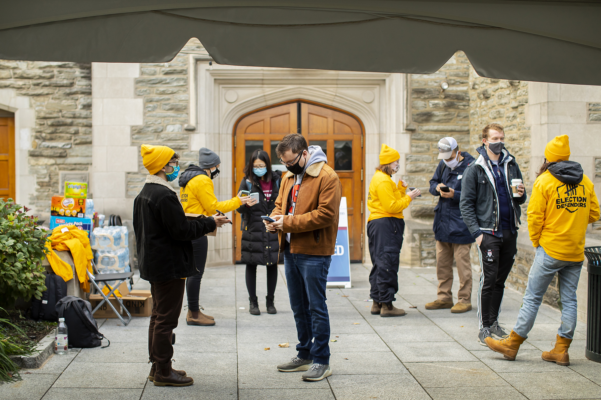 students prepare to vote outside a polling place on campus