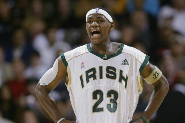 LeBron James, while in high school wearing his Irish jersey, holds his hands on his hips.
