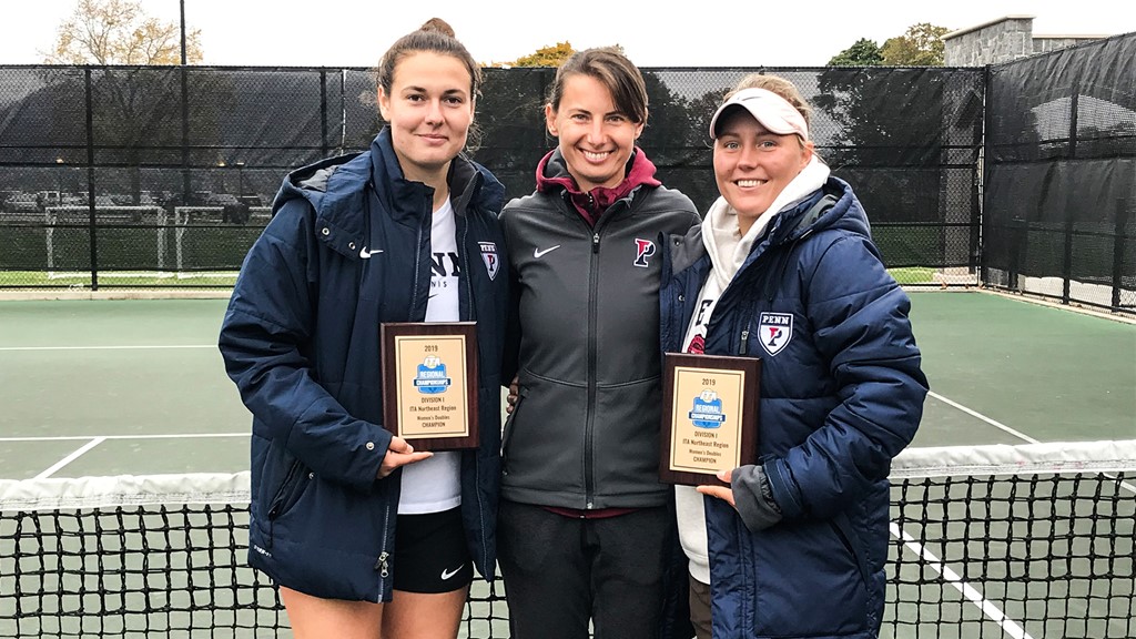 Junior Iuliia Bryzgalova, right, and senior Marija Curnic, left, hold plaques while standing with their coach (middle).