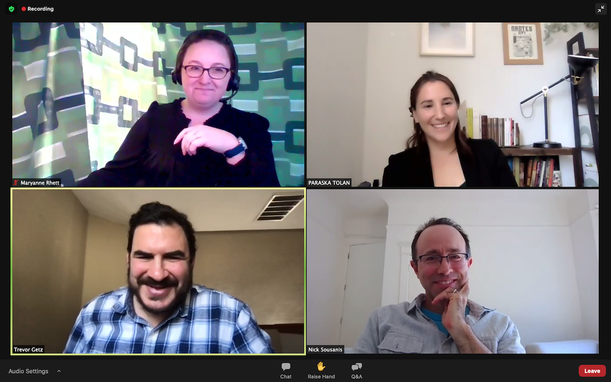 Four people smile in four separate screens on a Zoom video call.