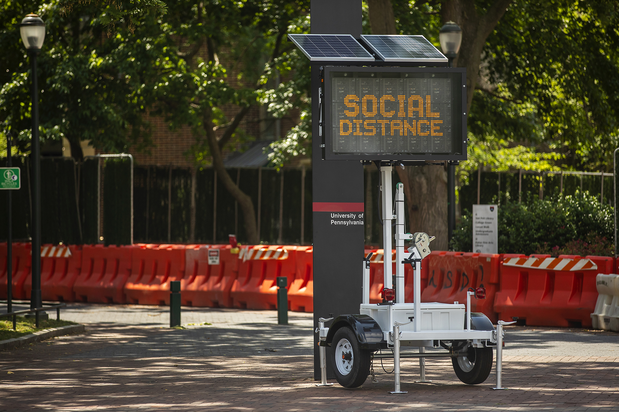 An LED sign on wheels outside a Penn walkway that reads SOCIAL DISTANCE