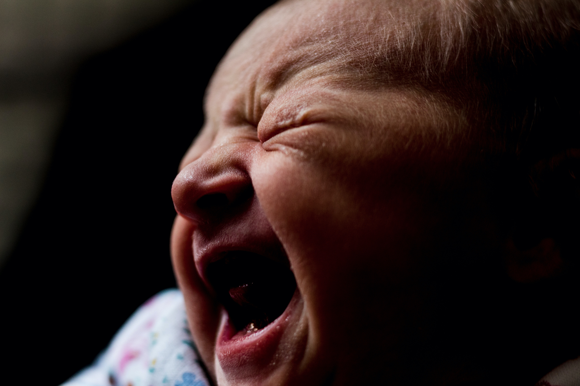 A close-up of a baby crying, mid-cry.