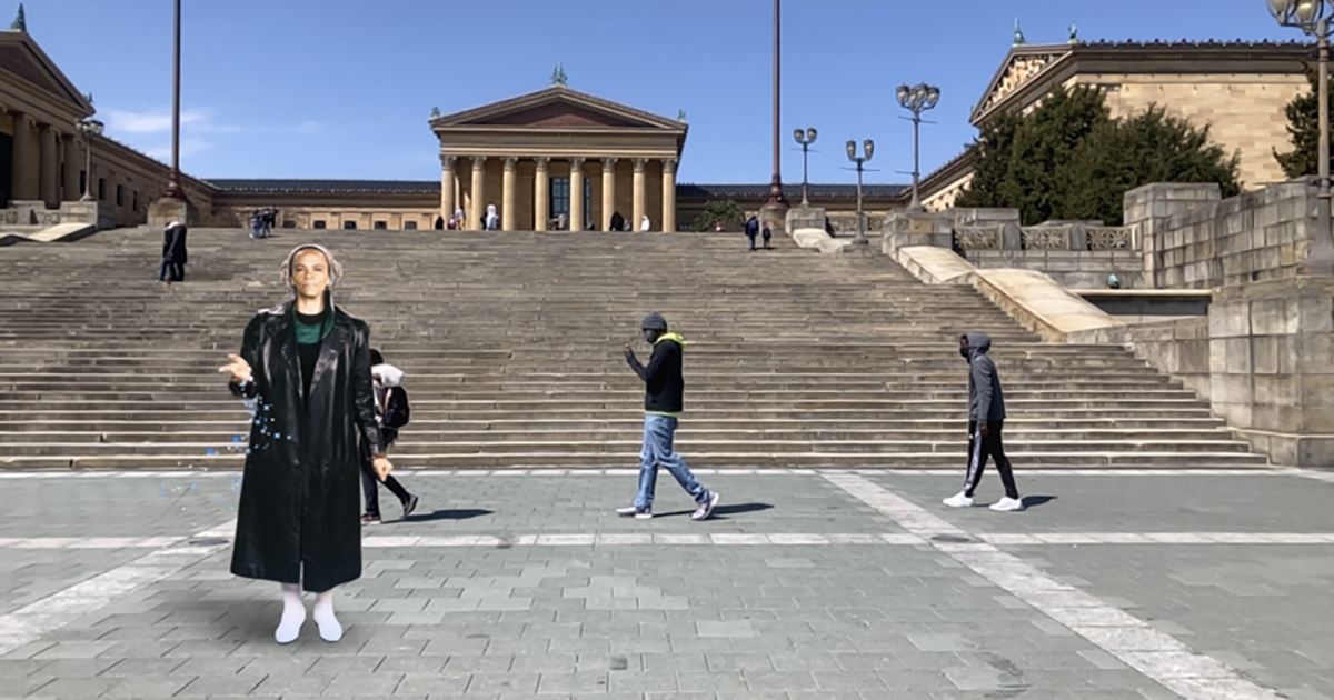 A digital image of Ursula Rucker standing at the base of the Philadelphia Art Museum steps with three people walking behind her.