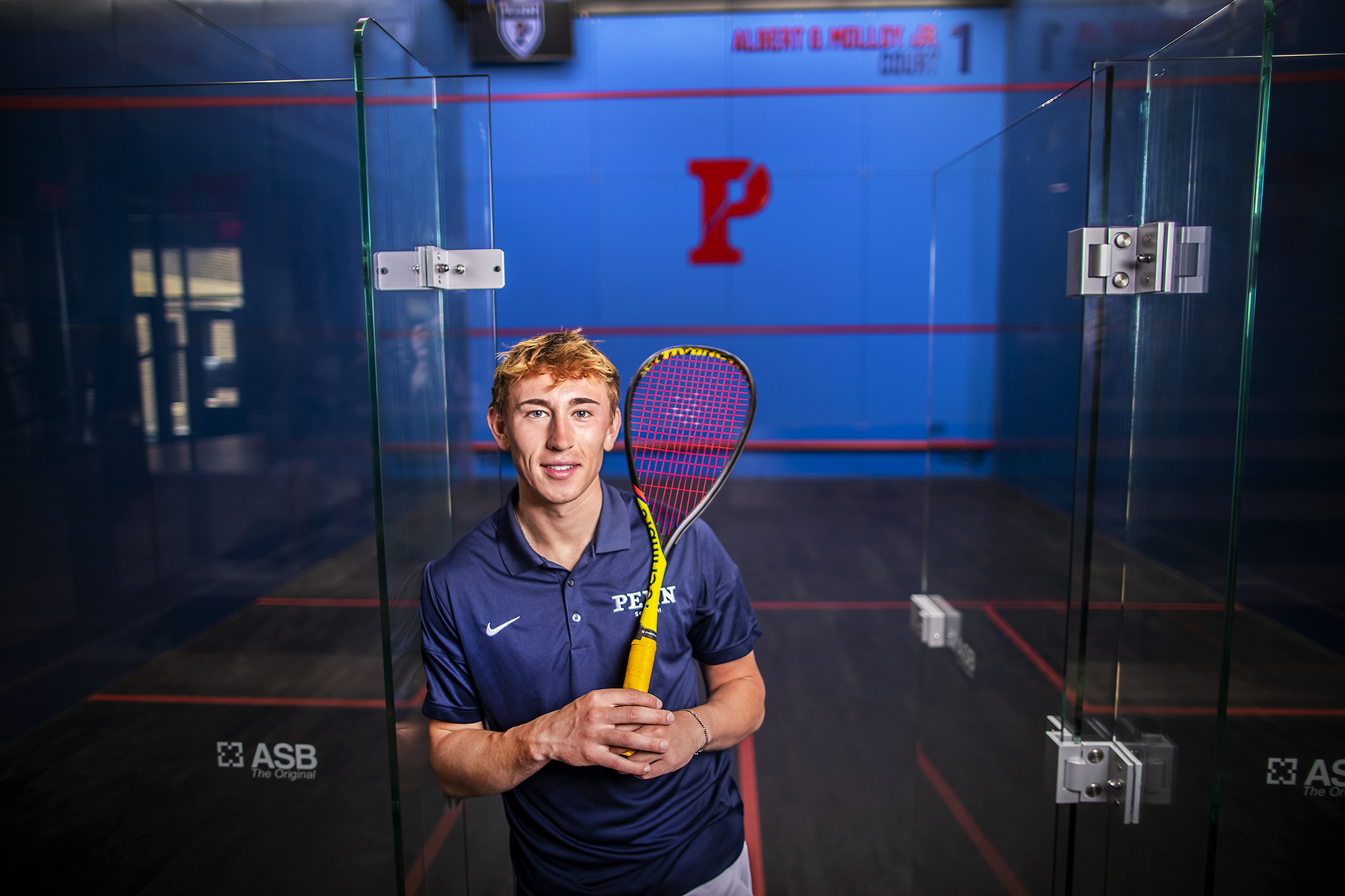 Andrew Douglas holds his racquet on his show in the Penn Squash Center.
