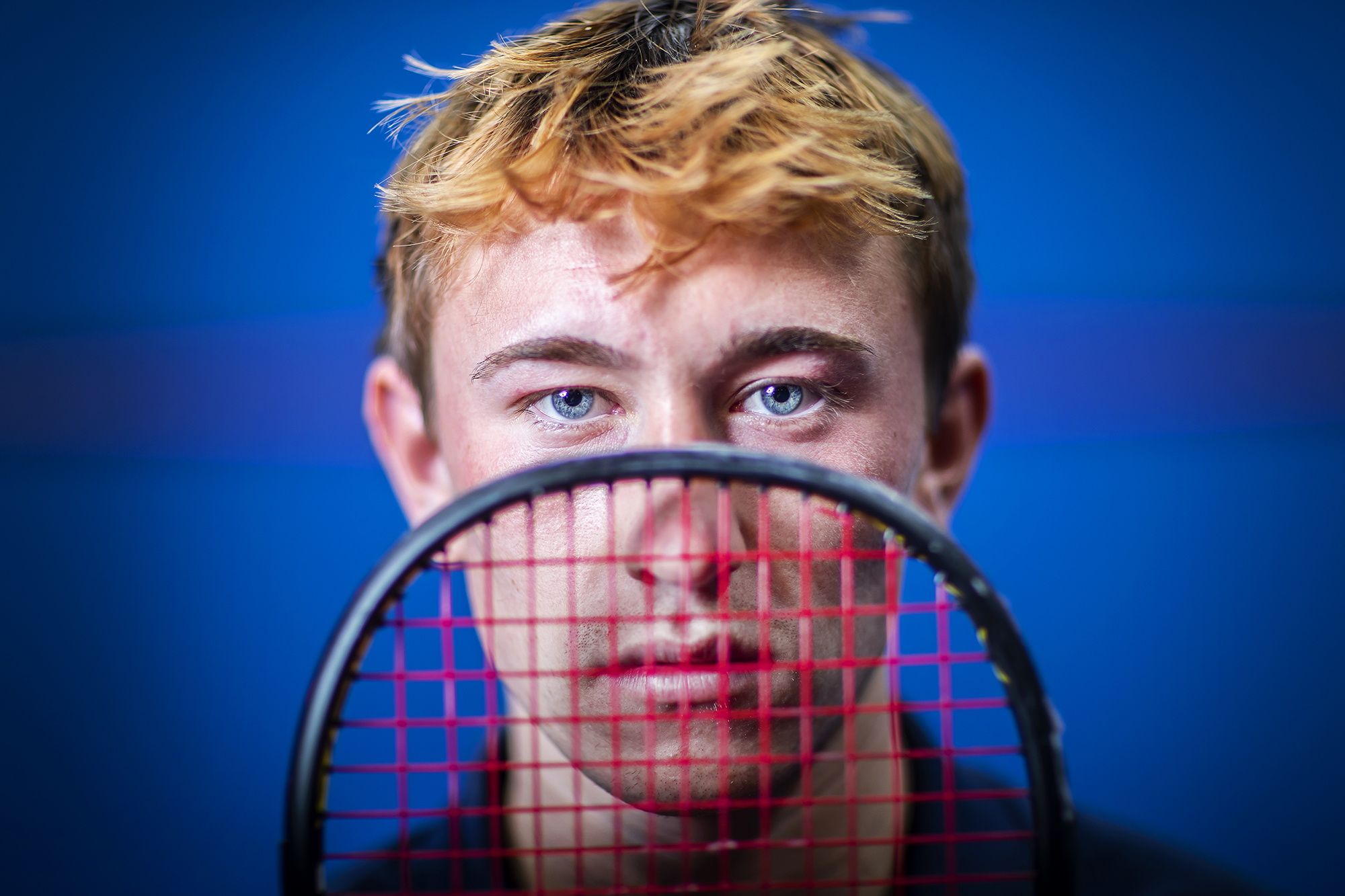 Andrew Douglas looks the the net on his squash racquet.