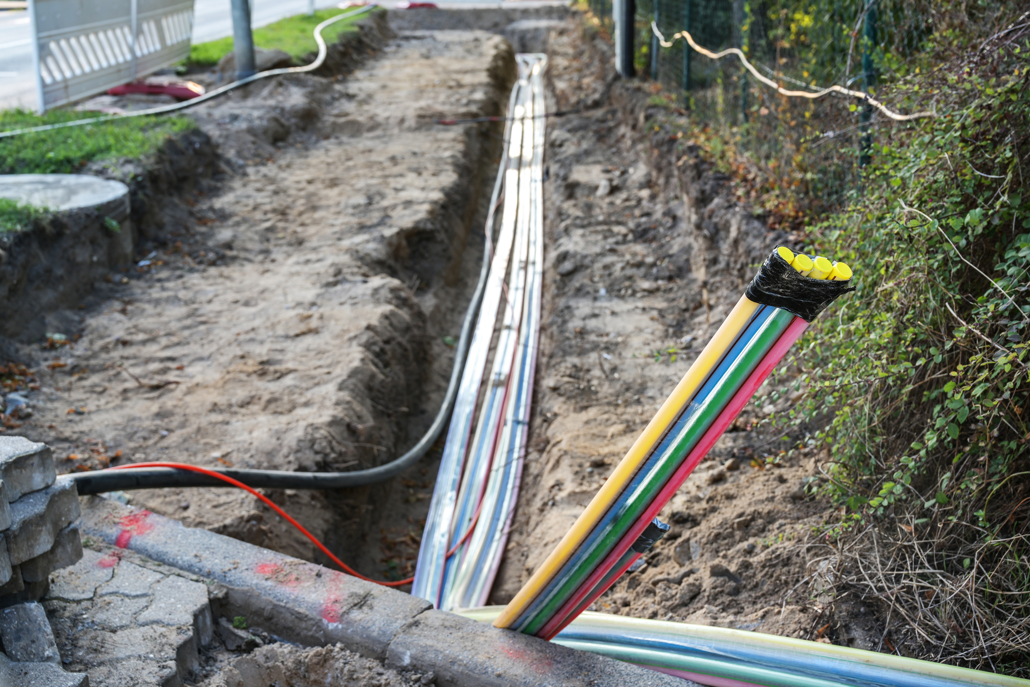 Fiber optic cables of multiple colors laid in trench