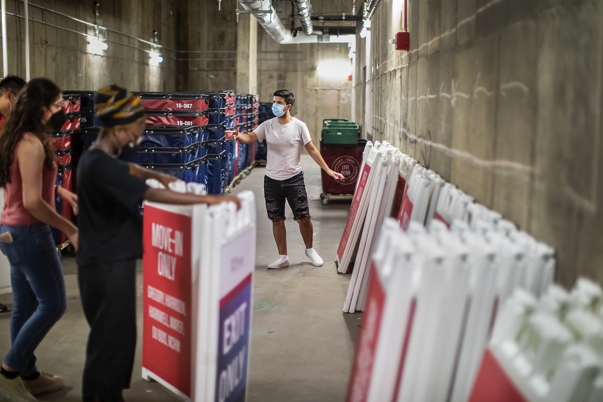 Student stands in basement filled with moving carts and signs