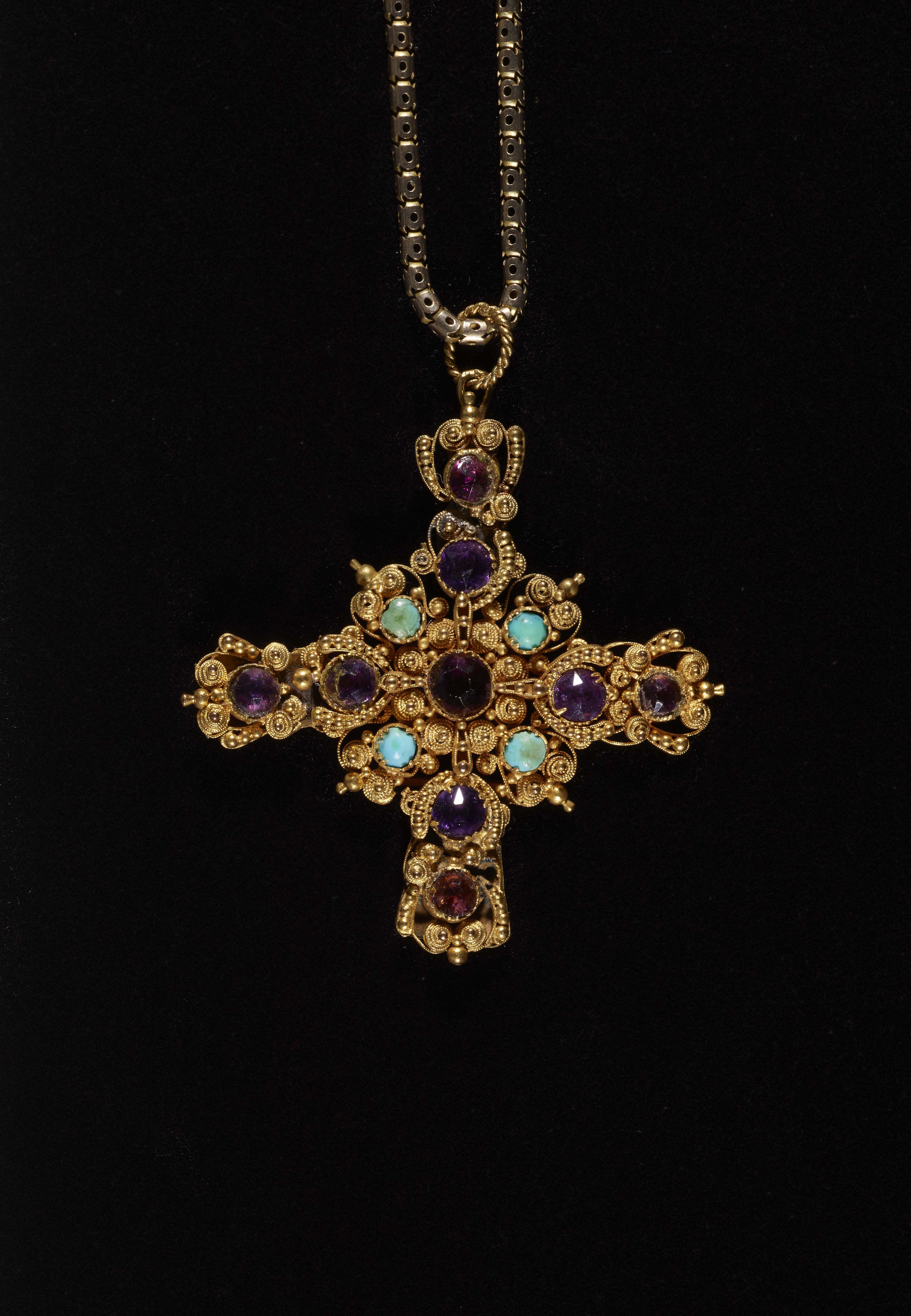 A gold crucifix necklace with inset gemstones
