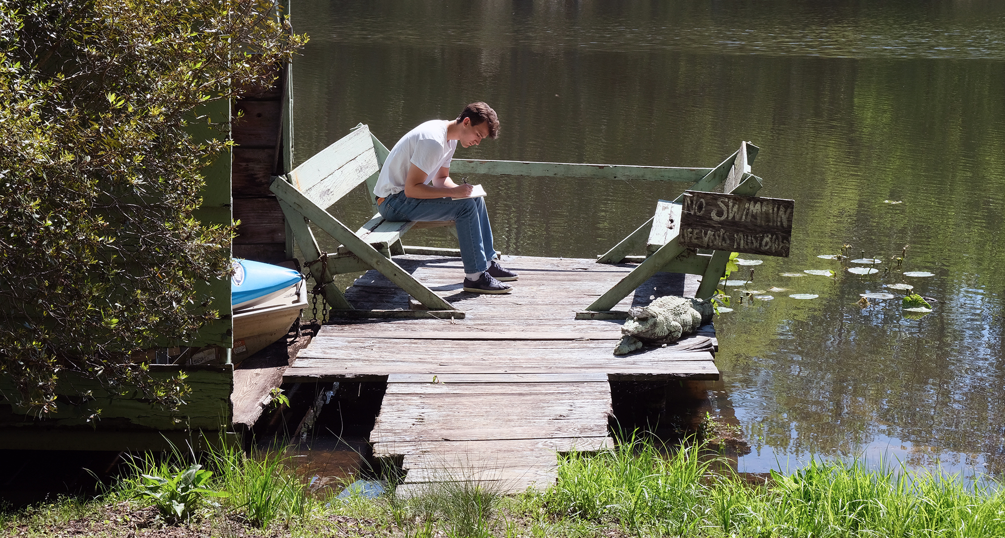 Max Strickberger on a dock writing