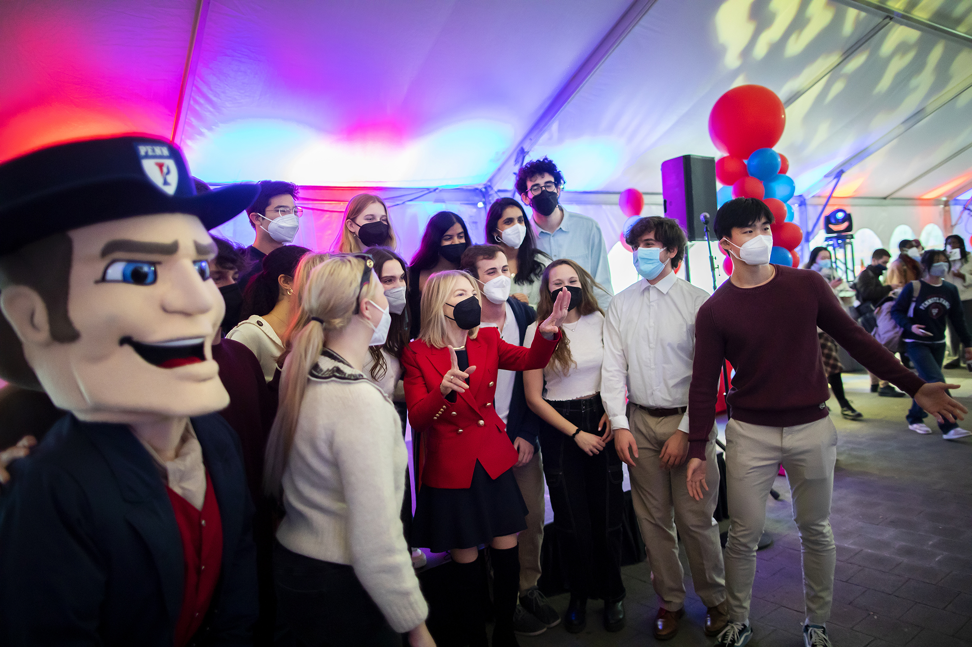 Penn President Amy Gutmann and a group of students and the Penn Quaker mascot.