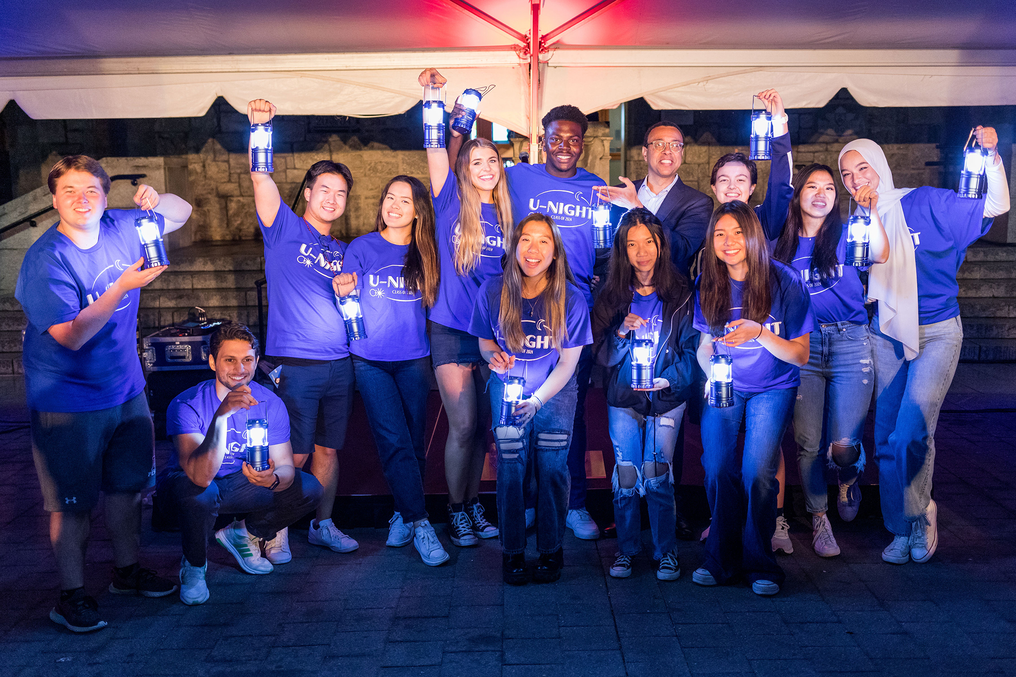 Wendell Pritchett and the members of the Class Board of 2022 in U-Night T-shirts pose with lanterns lit.
