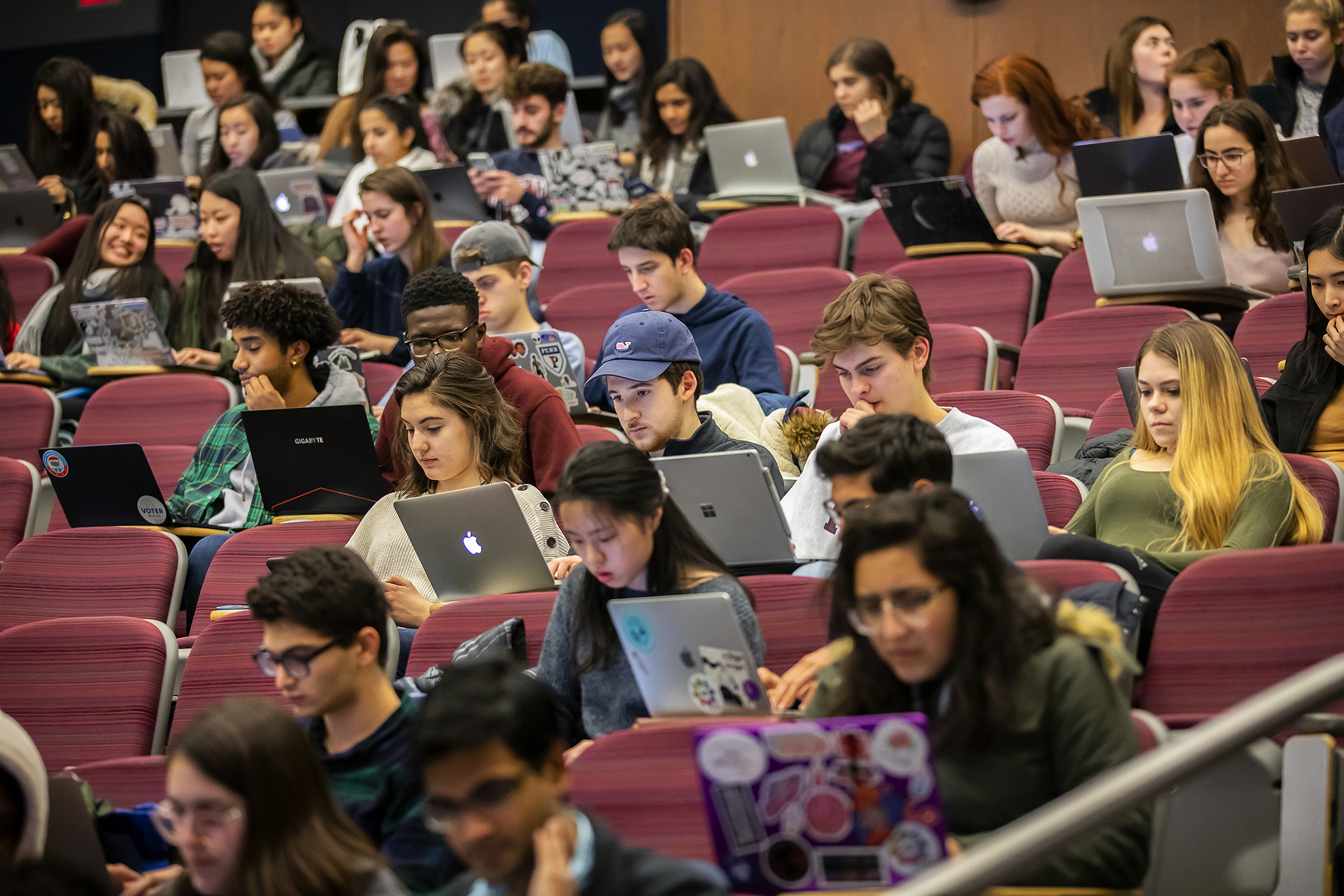 Students in an auditorium working on their laptops