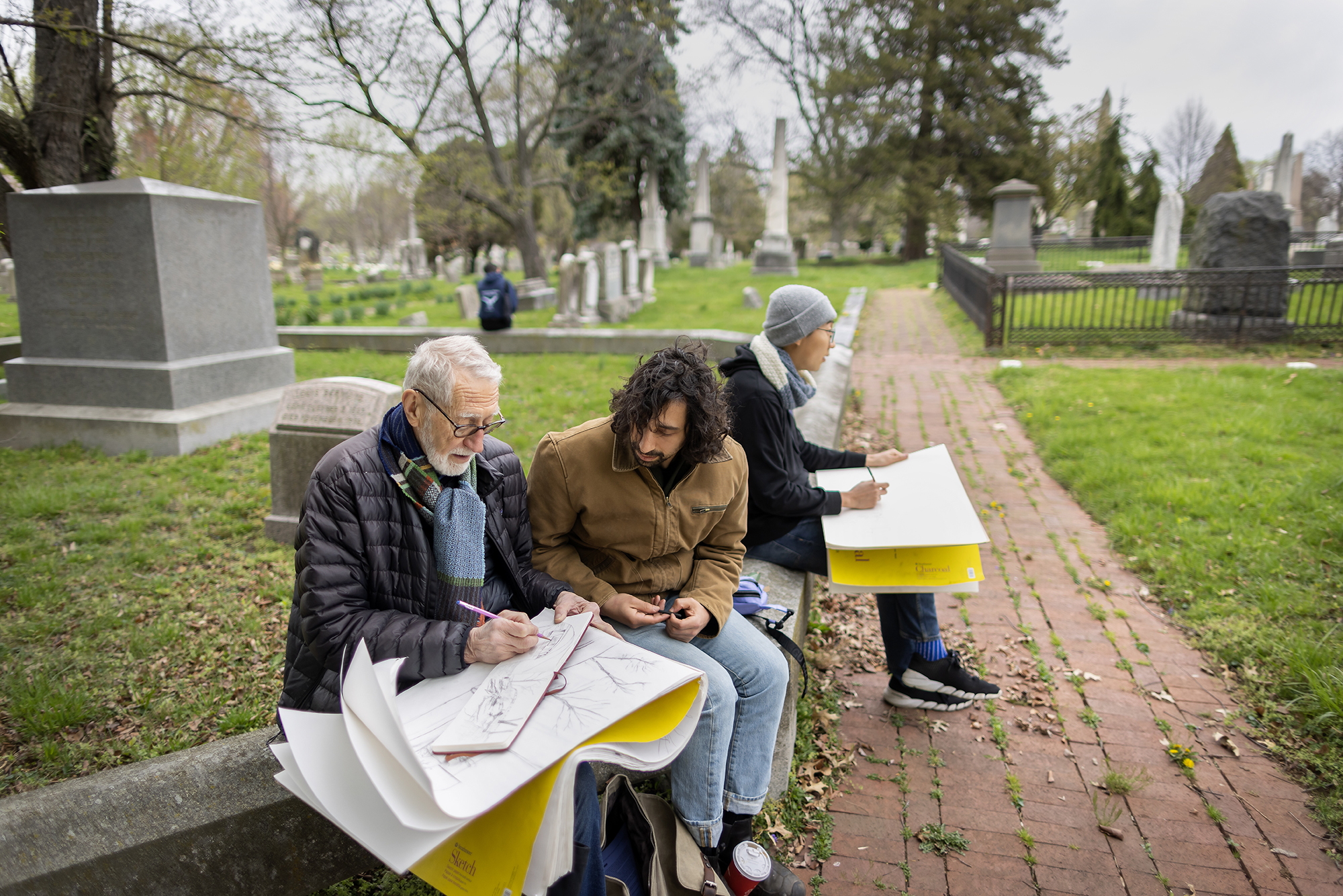 Laurie Olin and two students seated at Woodlands Cemetery with drawing supplies.