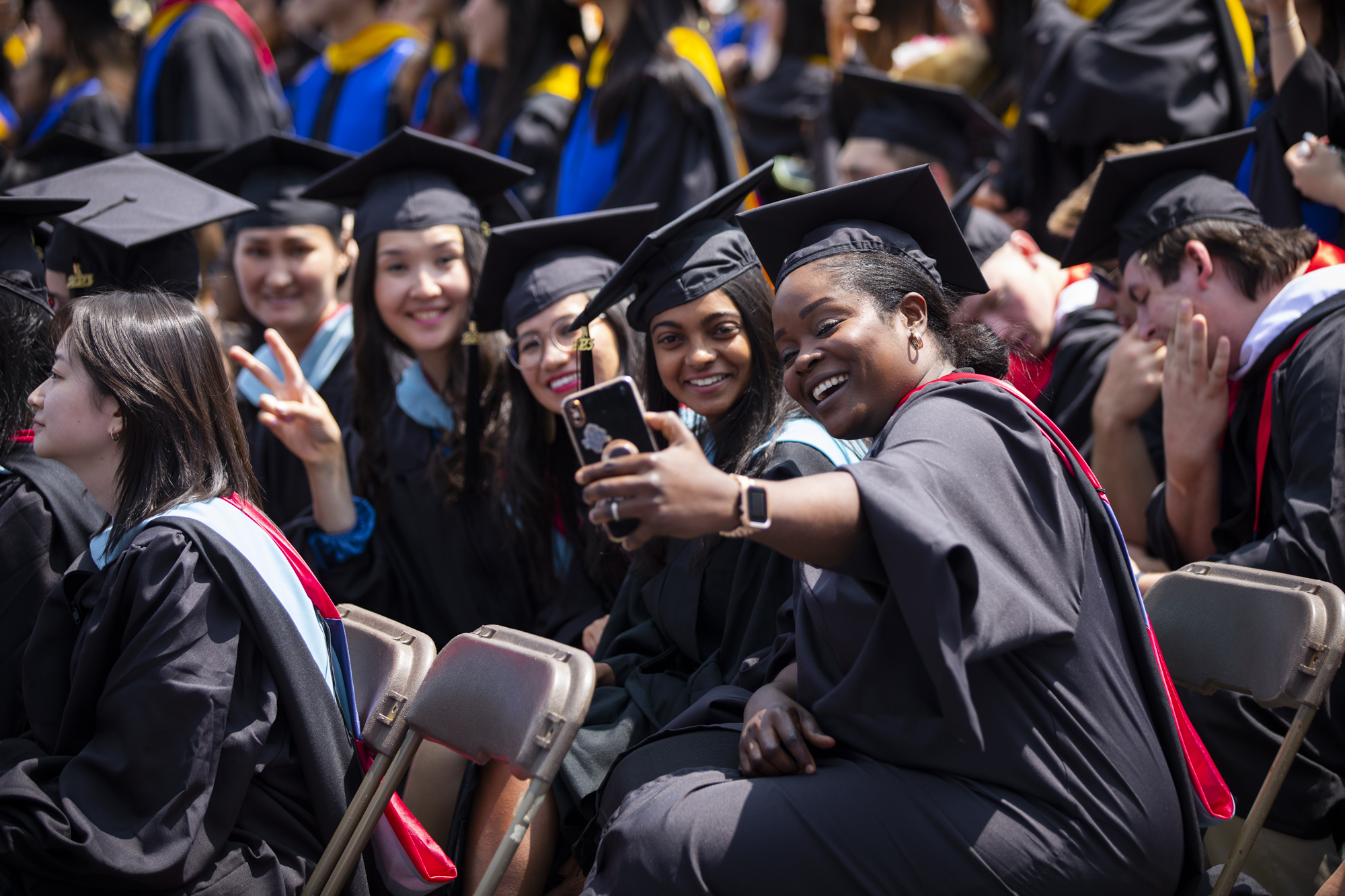 students take a selfie during commencement