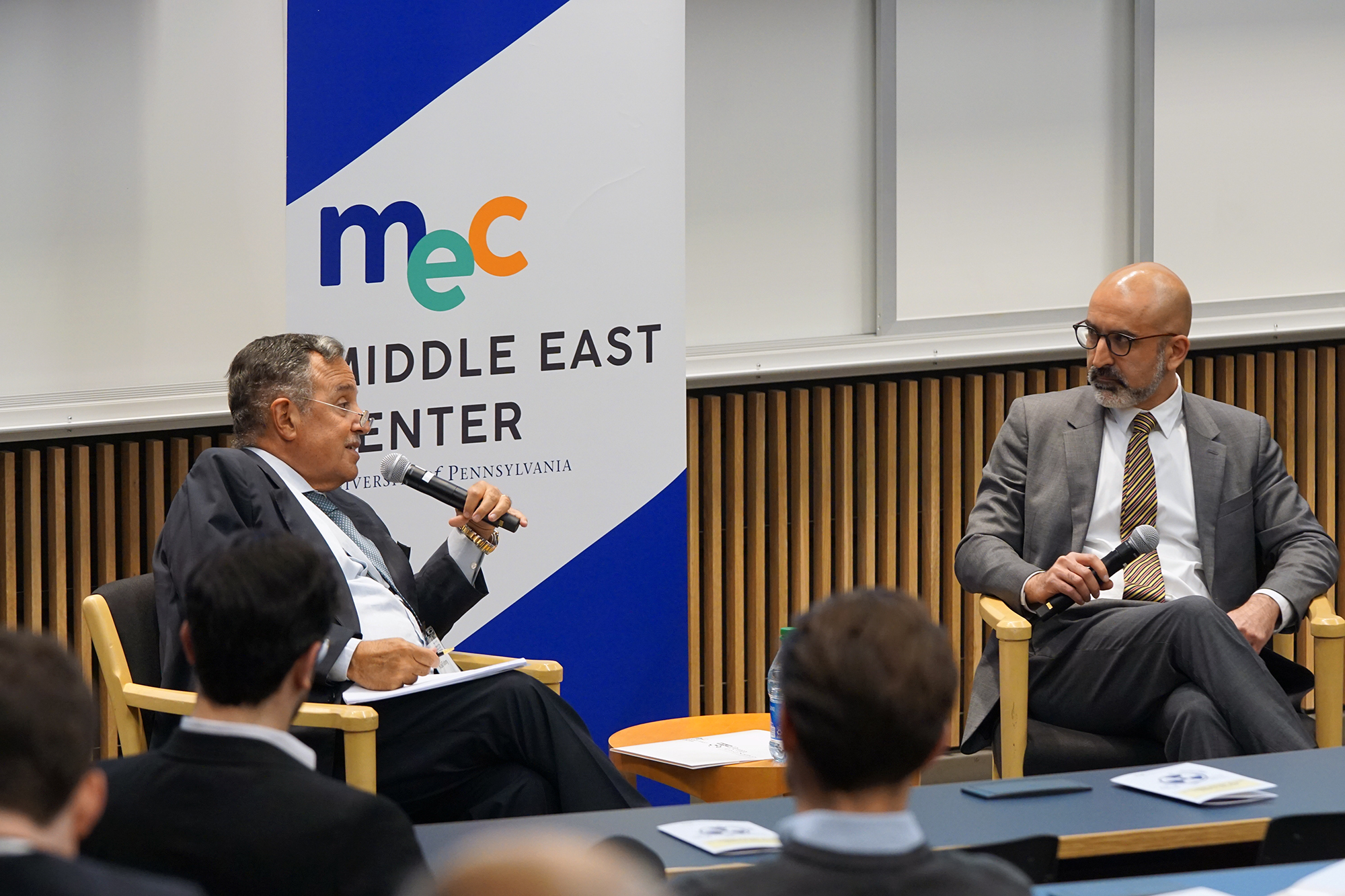 Nabil Fahmy sits in front of a sign reading Middle East Center, speaking into a microphone, as John Ghazvinian looks on, seated to Fahmy's left, the two separated by a low round side table.