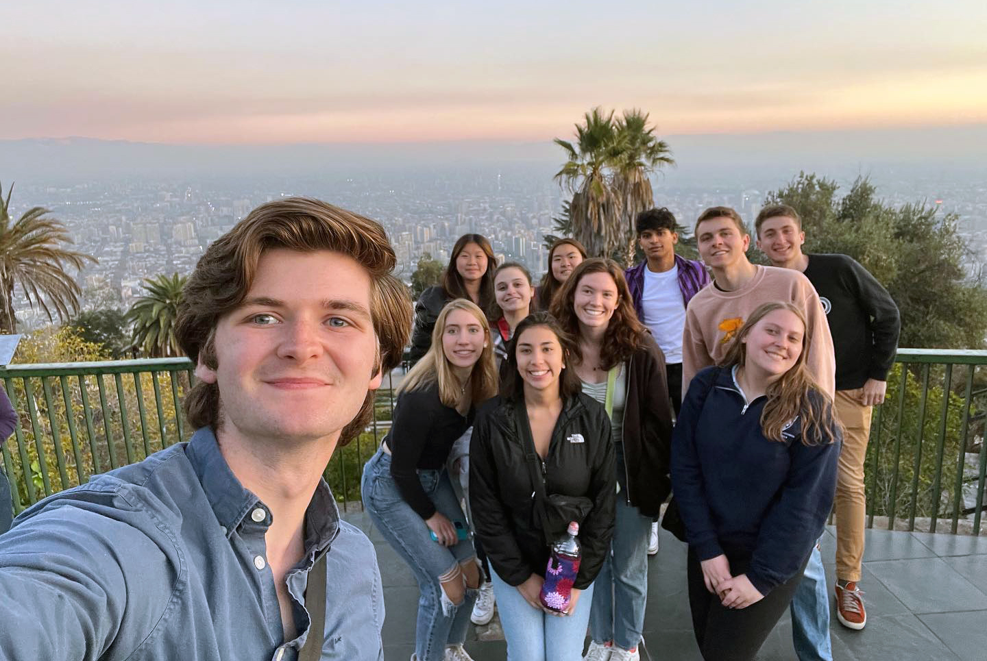 A group selfie shot of the Glee Club overlooking a cityscape in Santiago Chile.