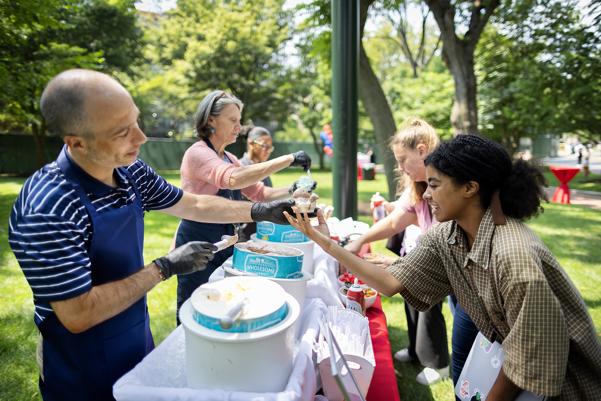 Mike Citro scoops ice cream for a guest on College Green.