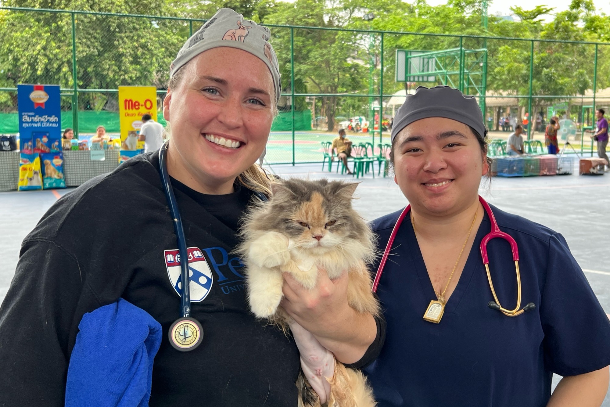 Amanda Patev and Fern Akkrawong with a cat at the Bangkok clinic.