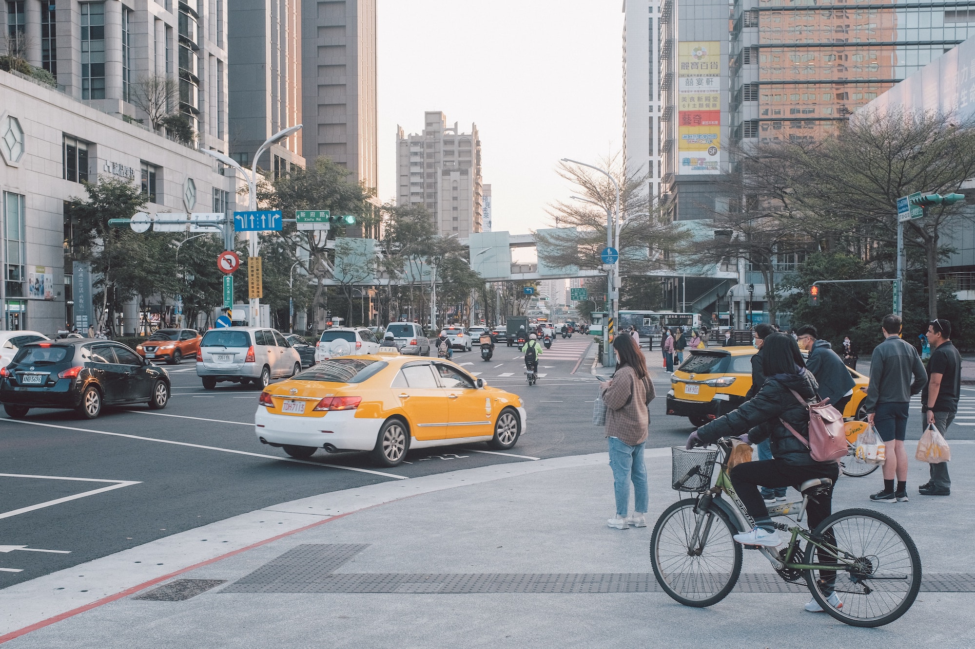 A busy street in Taipei, Taiwan, with people driving, biking, and walking