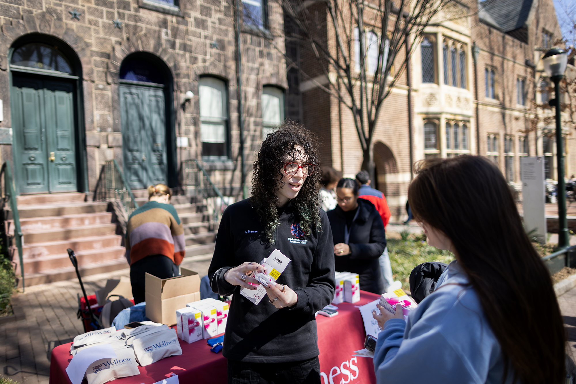 A member of MERT speaks with a woman during a Narcan giveaway and training on Locust Walk.