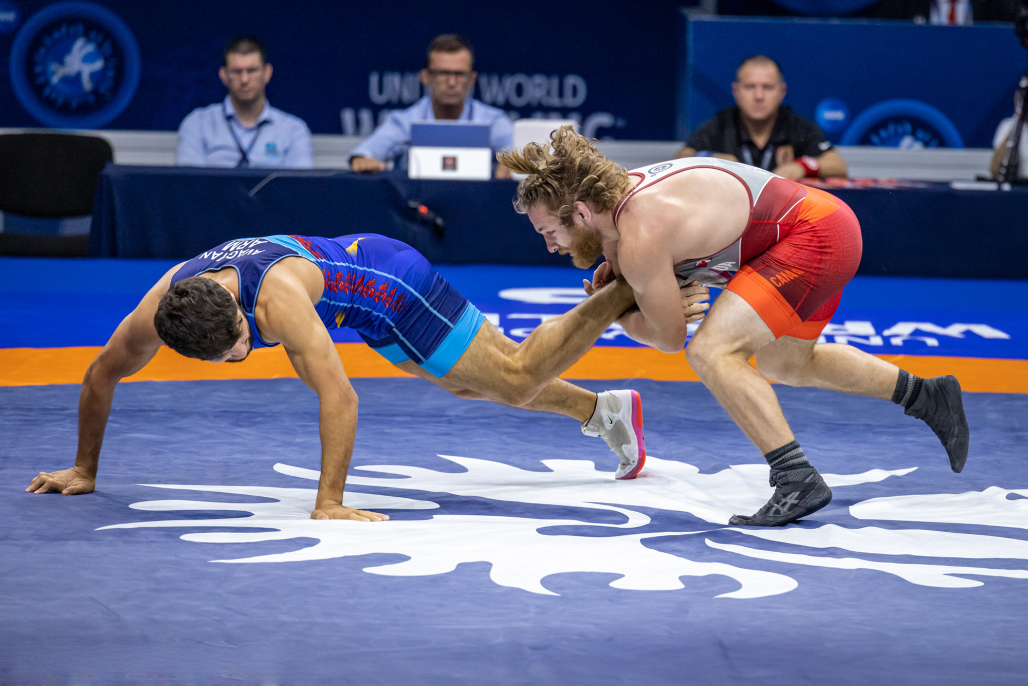 Wrestler Adam Thomson grabs his opponent by the left ankle in a match in Belgrade, Serbia.