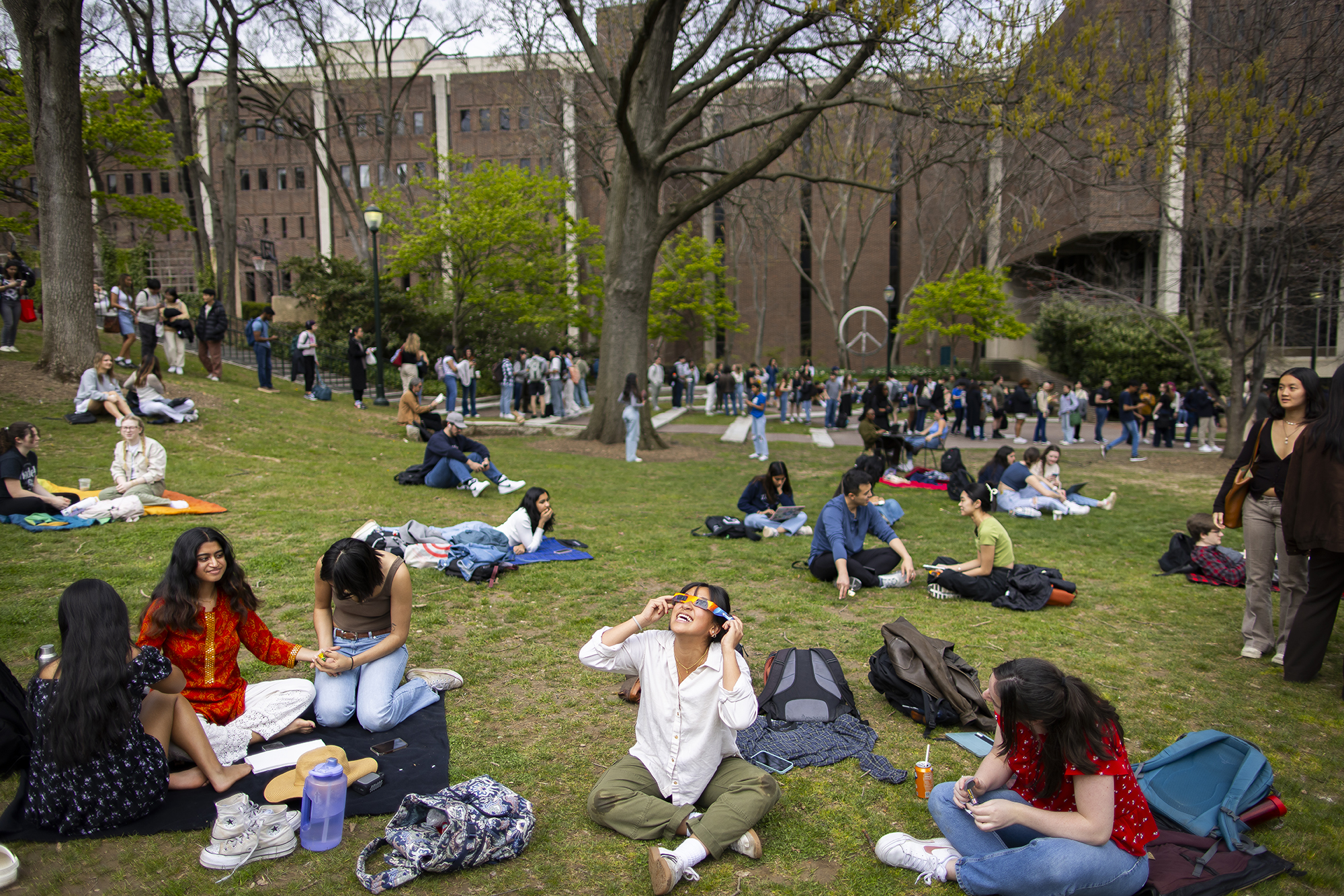 Students sit on Penn’s campus for the solar eclipse.
