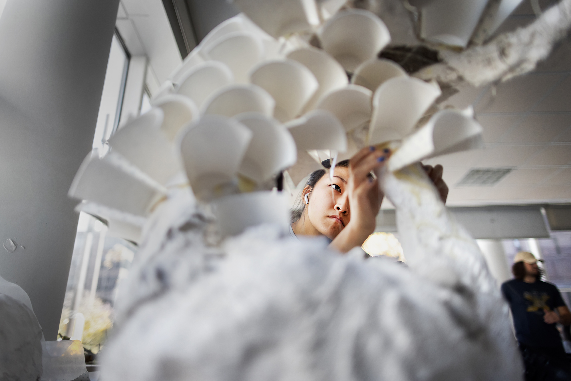 student using paper cups for a sculpture
