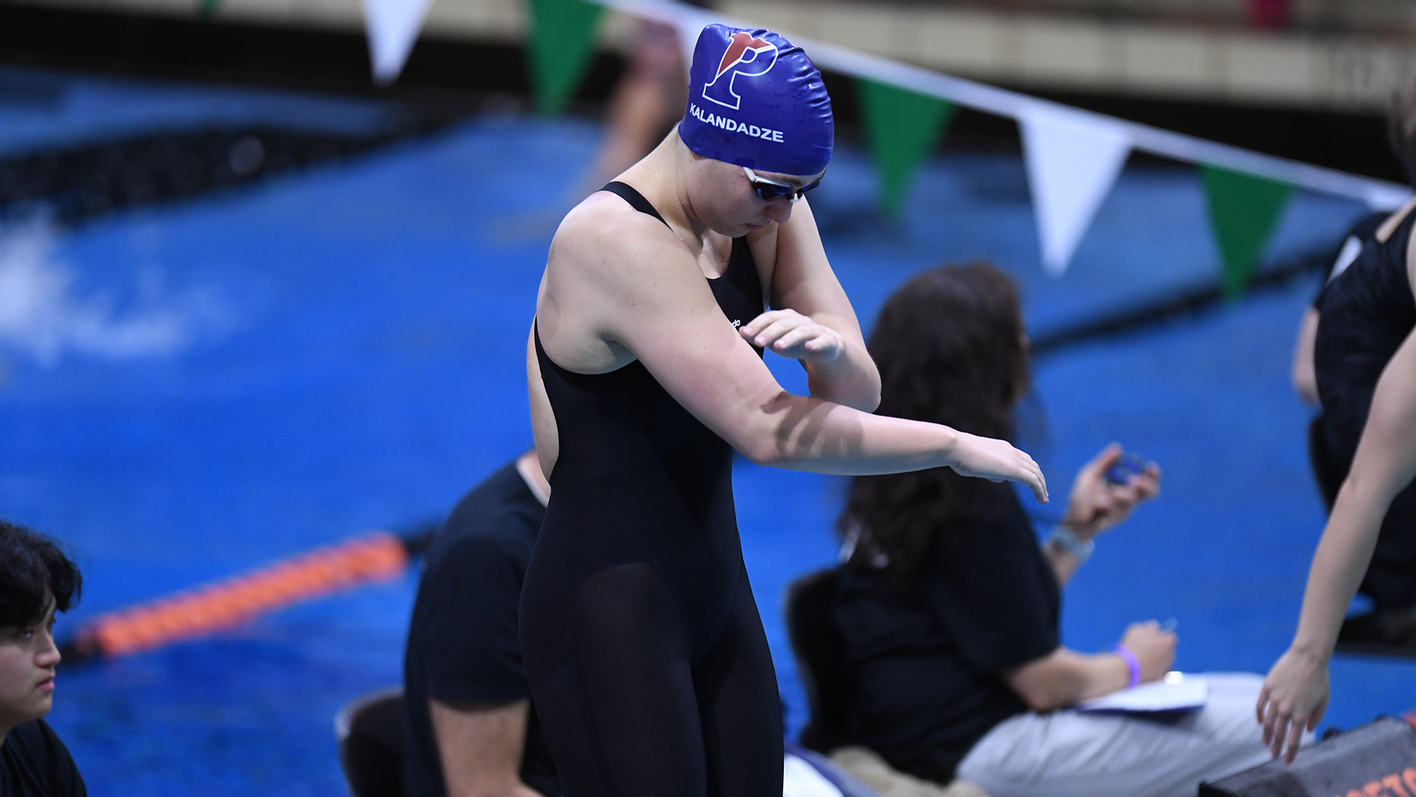 Anna Kalandadze, wearing her Penn swim cap, prepares herself to swim before a race.