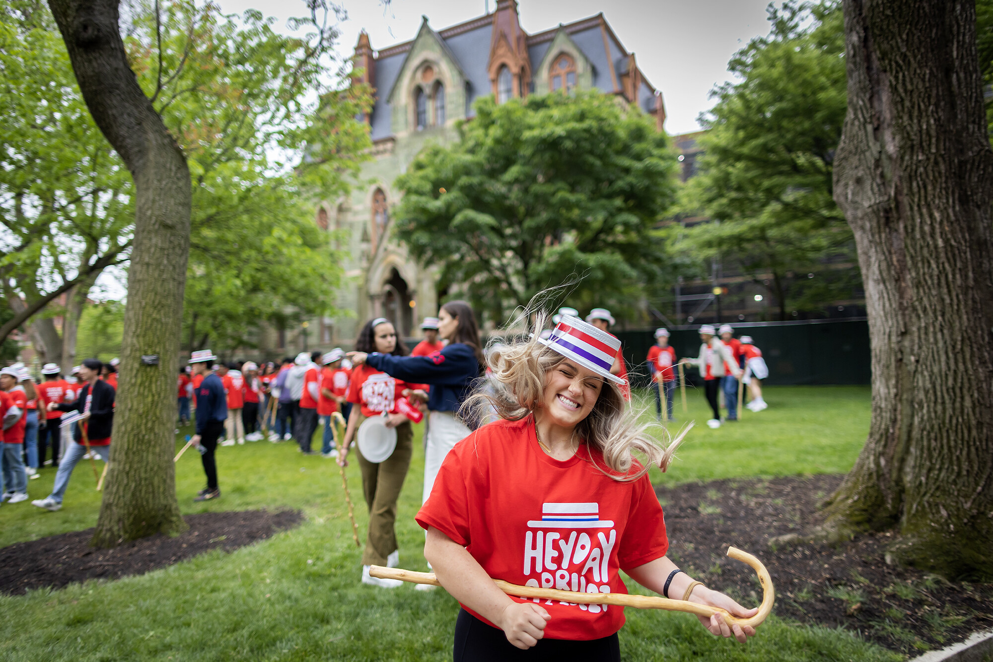student dancing with cane in front of college hall during hey day