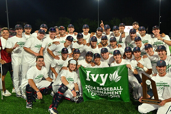 Members of the baseball team pose with the championship banner.