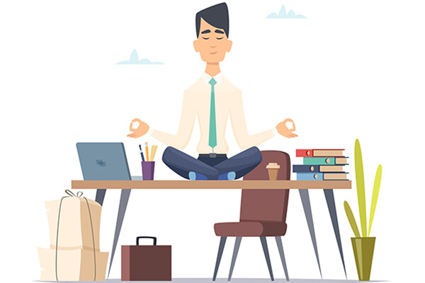 Person sitting on top of desk in meditative pose with laptop and books surrounding