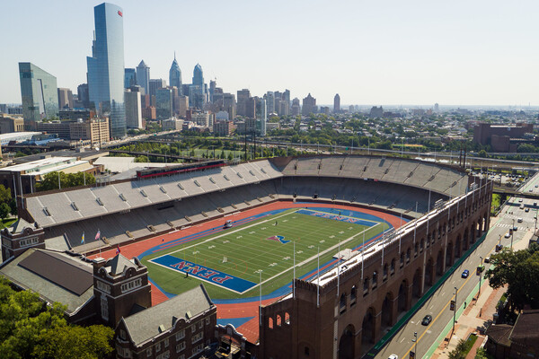 Penn's historic Franklin Field sits empty on a sunny day, with the Philadelphia skyline in the background.