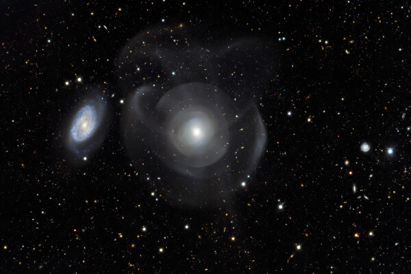 rendering of the elliptical galaxy NGC 474 and spiral galaxy 470 with star shells